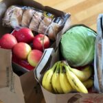 Bags of fresh produce on a wooden floor.