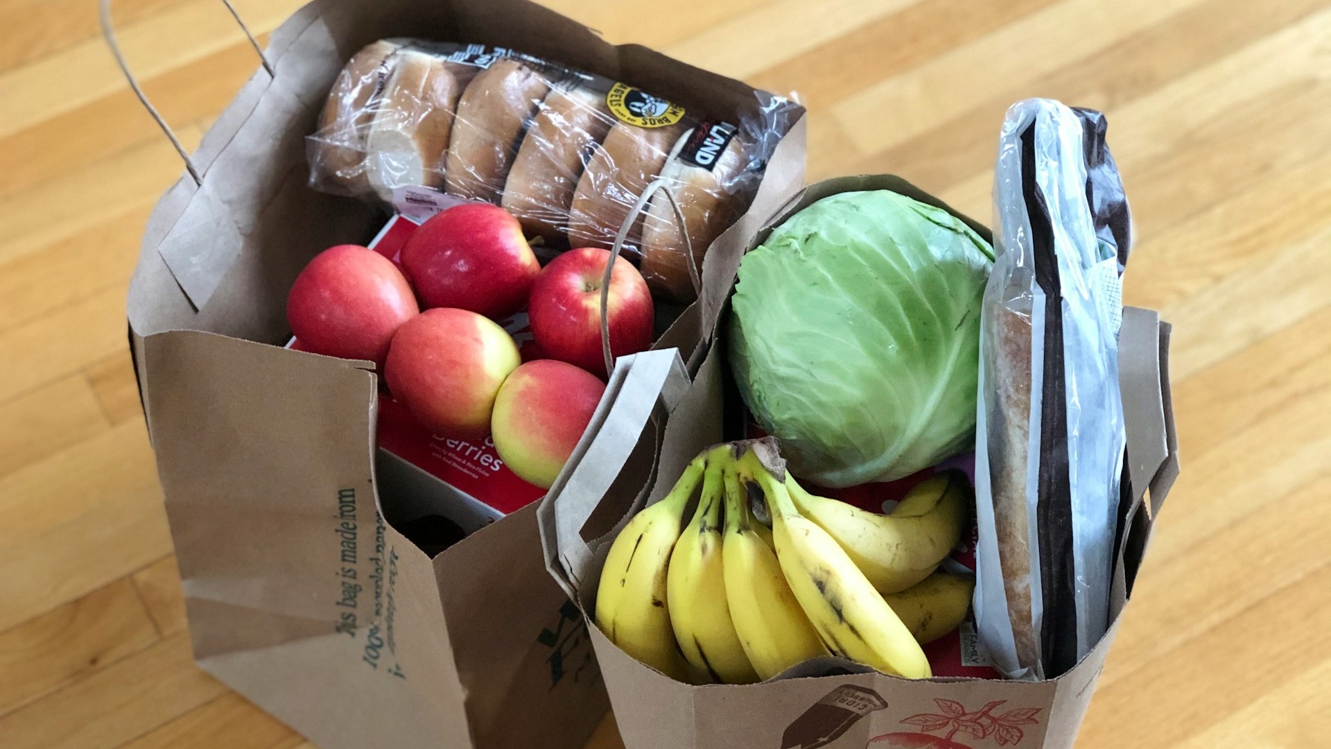 Bags of fresh produce on a wooden floor.
